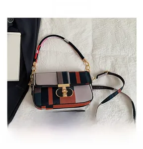 Detail view of colorful plaid handbag showing metal clasp, straps, and size comparison