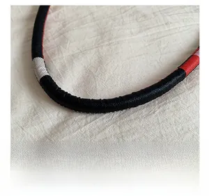 Detail of the tricolor woven handle with black, red and white pattern on hand bag