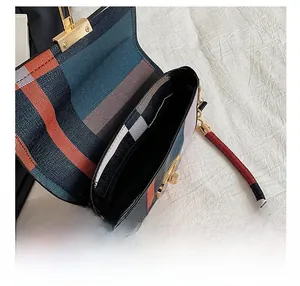 Interior view of checkered shoulder bag showing the main compartment and zipper pocket
