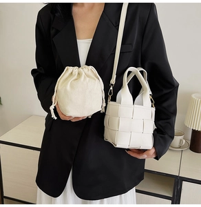 Sac seau blanc tressé avec pochette en toile sur une tenue de blazer noir