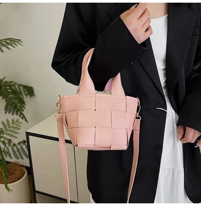 Détail du sac seau en cuir tressé rose avec cordon de serrage en toile à l'intérieur