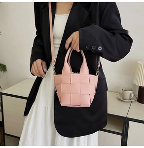 Vue détaillée du sac à main tissé rose en similicuir avec poignée assortie et cordon interne