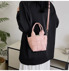 Détail d'un sac à main tissé rose avec doublure à cordon et accessoires dorés élégants