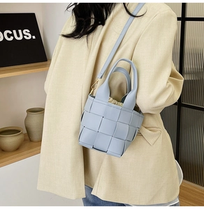 Détail du sac seau tressé bleu clair avec doublure à cordon et fine bandoulière