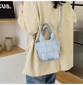 Détail du sac à main en cuir tressé bleu clair avec bandoulière sur le mannequin