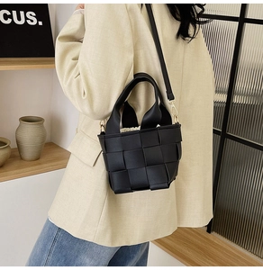 Détail d'un sac à main noir tressé avec pochette beige à cordon et bandoulière amovible
