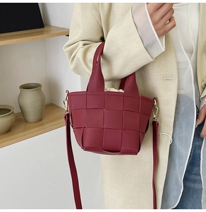Détail d'un sac à main tressé bordeaux avec bandoulière amovible et pochette interne