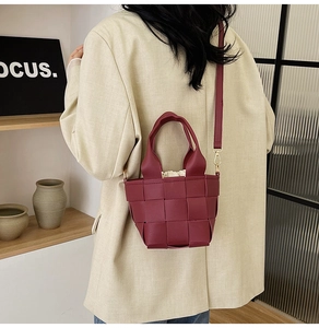 Détail du sac seau tressé bordeaux avec doublure crème et bandoulière réglable