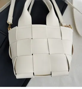 Détail du sac à main tressé crème avec ferrures dorées et bandoulière amovible