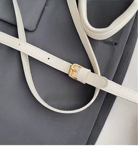 Détail de la bandoulière en cuir blanc avec boucle dorée et coutures de précision