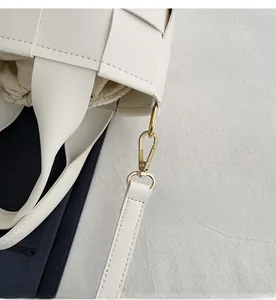 Détail du sac tressé blanc avec crochet en métal doré et doublure à cordon amovible