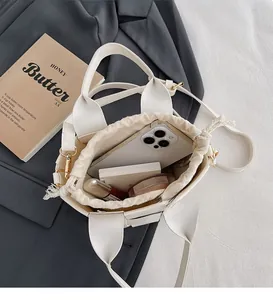 Détail du sac seau tissé blanc avec doublure à cordon et espace pour articles quotidiens
