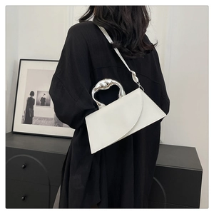Schicke weiße PU-Handtasche mit silbernem Skulpturgriff getragen von einem Model