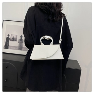 Detail of white square crossbody bag with unique liquid silver metal top handle
