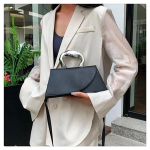Detail einer eleganten schwarzen matten Ledertasche mit einzigartigem silbernem Metallgriff
