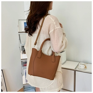 Sac seau en cuir marron avec poignée supérieure et bandoulière pour un usage quotidien