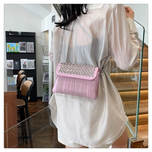 Detailed view of pink crossbody bag with sparkling rhinestones and silver chain tassels
