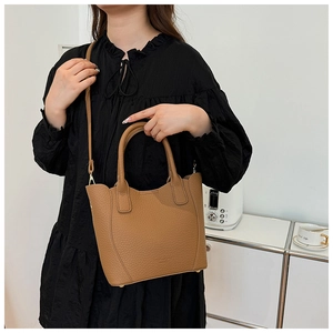 Détail du sac seau en cuir grainé kaki avec poignée ronde et fine bandoulière réglable