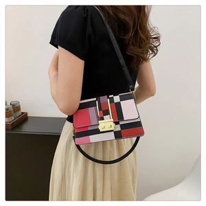 Detailed view of women's crossbody bag with geometric color-block and golden lock