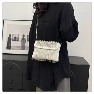 Detail of evening clutch bag featuring rhinestone fringe and silver chain strap
