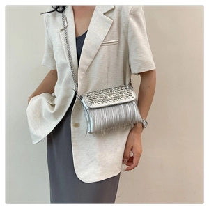 Close-up of sparkling silver rhinestone tassels and metallic chain on small square bag