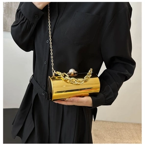 Detailansicht der goldenen zylindrischen Abendtasche mit Perlenverschluss und Kette