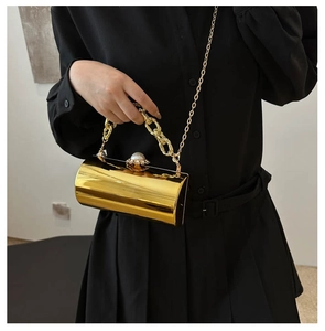 Nahaufnahme der goldenen runden Abendtasche mit Perlenverschluss und Metallringgriff
