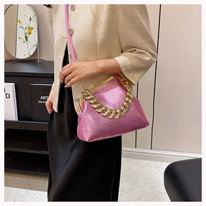Close-up of pink litchi texture shell bag with gold chain handle and metal clasp