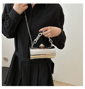 Details der silbernen zylindrischen Acryl-Clutch mit Spiegeleffekt und Perlenverschluss