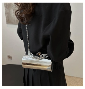 Makroaufnahme der silbernen Zylindertasche mit grober Metallkette und langem Riemen