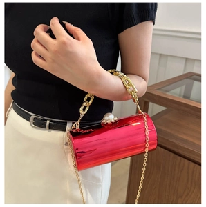 Makroaufnahme der roten Acryl-Abendtasche mit goldener Kette und Perlenverschluss