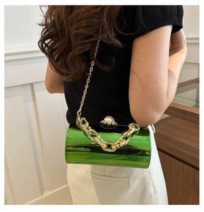 Details der metallisch grünen Zylinder-Abendtasche mit Goldkette und Perlenverschluss
