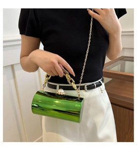 Makroaufnahme der grünen Metallic-Zylinder-Abendtasche mit Goldkette und Perlenverschluss