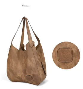 Macro detail of the vintage brown leather bucket bag showing embossed brand logo and texture