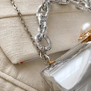 Detail der Acryl-Zylindertasche mit großem Perlenverschluss und silberner Gliederkette