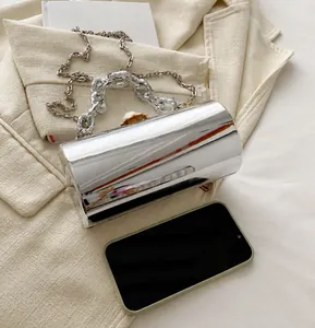 Silberne Abendtasche mit Perlenverschluss und Kettenhenkel im Größenvergleich zum Handy