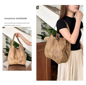 Detail view of large vintage brown tote bag showing embossed logo and shoulder strap style