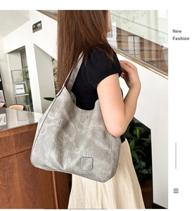 Detail of vintage grey washed faux leather tote bag with square logo patch