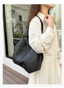 Detail of a black soft faux leather multi-layer tote bag with embossed square decor