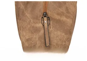 Detail of smooth metal zipper closure on brown vintage bucket bag with soft leather texture