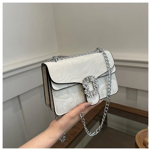 Detail of white marble pattern crossbody bag with rhinestone buckle and silver chain