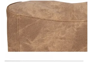 Detailed close-up of neat stitching and vintage brown synthetic leather texture on bag