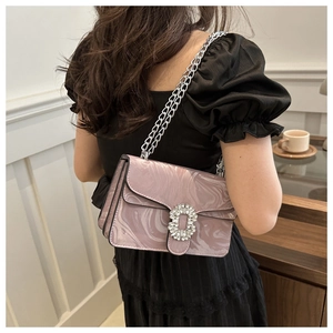 Detail of pink marble textured crossbody bag with rhinestone buckle and silver chain