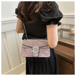 Detailed view of pink marble pattern chain bag with sparkling rhinestone buckle on a model