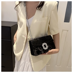 Detail of black crossbody bag with shiny marble texture and large crystal square buckle