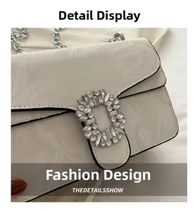 Detail of white marble pattern handbag with silver chain and rhinestone buckle