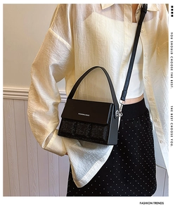 Detail of a black sequined crossbody bag showing the fashion texture and strap on a model