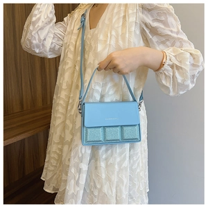 Close-up of light blue fashion box bag with glitter texture and silver hardware details