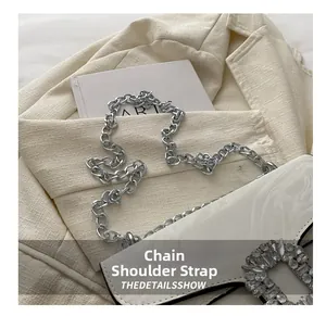 Close-up of a white leather crossbody bag featuring a large sparkling crystal buckle