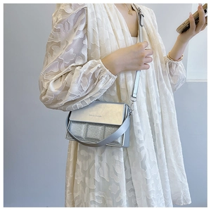 Detail of silver sequined crossbody bag showing glitter texture and glossy metallic finish